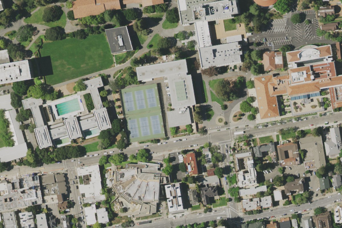 Real aerial photograph of a university campus with tennis courts and vehicles on the surrounding streets outlined by an object-detection model.